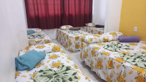 a room with four beds and a couch at Hotel SANTA CLARA in Belém