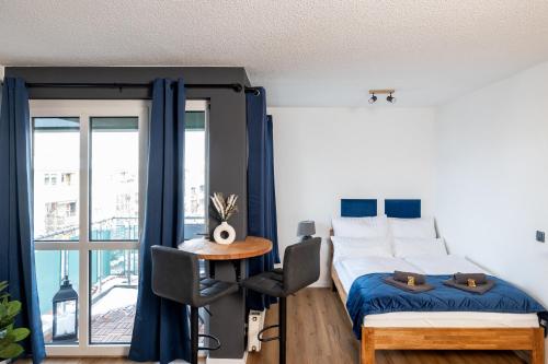 sypialnia z łóżkiem, stołem i oknem w obiekcie Sunnybelle Appartements Dresden I w Dreźnie