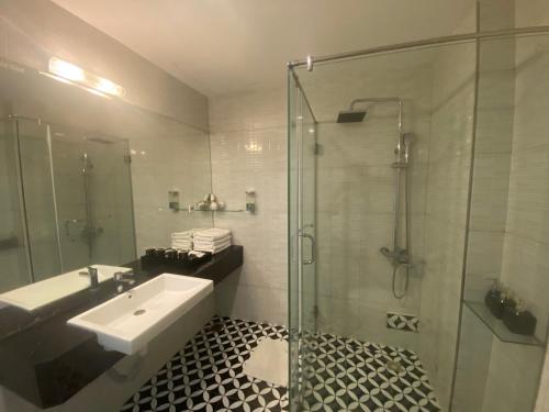 a bathroom with a sink and a glass shower at Eclipse Legend Hotel in Hanoi