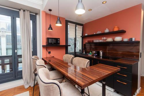 une salle à manger avec une table et des chaises en bois dans l'établissement Apartment Center of Paris by Studio prestige, à Paris