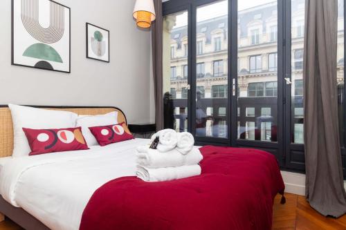 een slaapkamer met een bed met handdoeken erop bij Apartment Center of Paris by Studio prestige in Parijs
