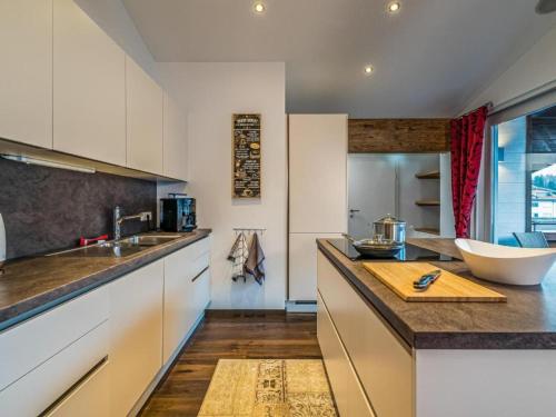 uma cozinha com armários brancos e uma bancada em Penthouse Julia em Niedernsill