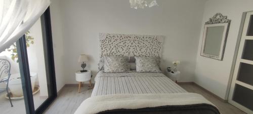 sypialnia z łóżkiem z szarym i białym zagłówkiem w obiekcie LA MAISON DE MARIE A 8 mn des plages w Perpignanie