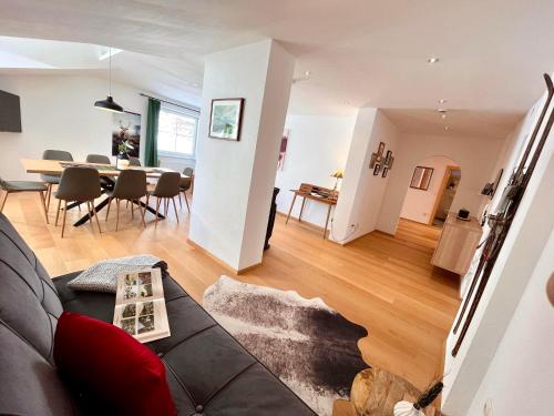 - un salon avec un canapé et une salle à manger dans l'établissement Landhaus Alpenzeit, à Arzl im Pitztal