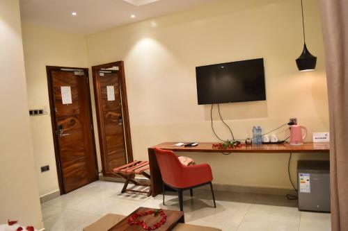 a room with a desk and a television on the wall at Millennium Terrace Hotel in Kampala