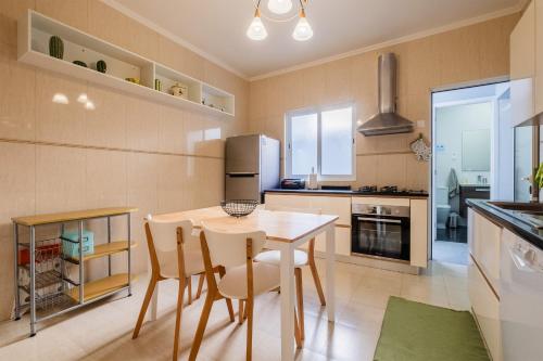 a kitchen with a table and chairs and a refrigerator at Casa da Nau in Ponta Delgada