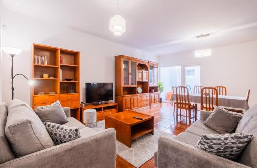 a living room with two couches and a television at Casa da Nau in Ponta Delgada