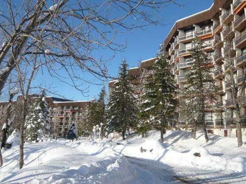 une rue enneigée devant un bâtiment dans l'établissement Charmant 2 pièces pour 4 pers. au pied des pistes avec balcons et parking privatif - FR-1-689-44, à Villard-de-Lans