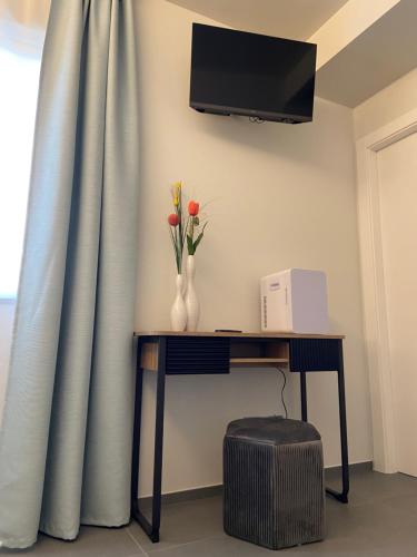 una mesa con flores y un televisor en la pared en ETNA STONE, en Zafferana Etnea