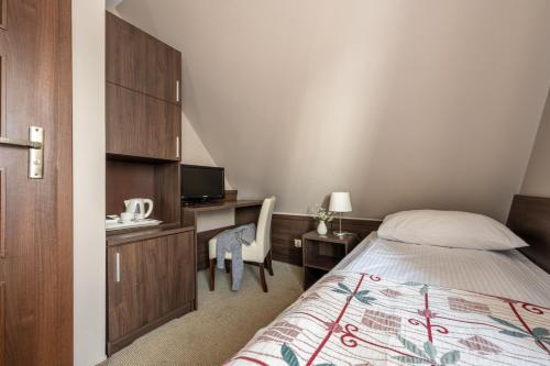 a bedroom with a bed and a desk with a computer at Dom Wczasowy Grań in Zakopane