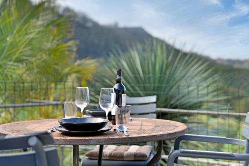 a wooden table with a bottle of wine and glasses at Casa Lomo el Aire Aceviño in Tegueste