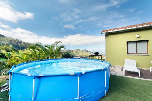 a large blue hot tub on a lawn next to a house at Casa Lomo el Aire Aceviño in Tegueste