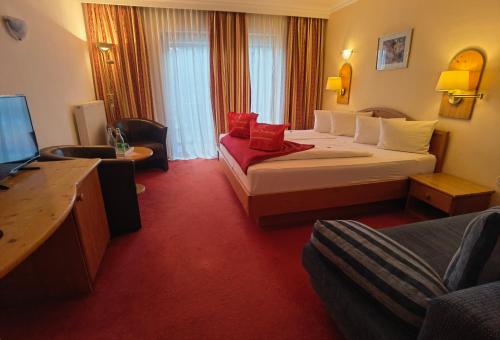 プレッセッガー・ゼーにあるHotel Kärntnerhof & SeeBlick Suitenの大型ベッドとテレビが備わるホテルルームです。