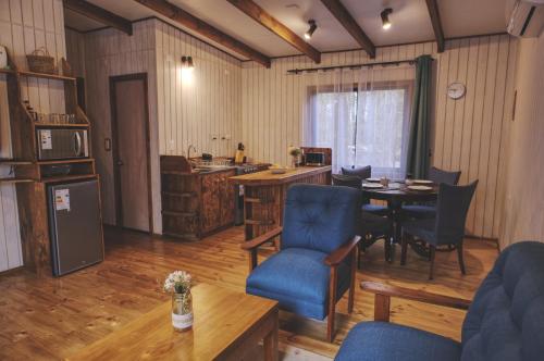 ein Wohnzimmer mit einem Tisch und Stühlen sowie eine Küche in der Unterkunft Cabaña Los Mañios in Puerto Montt