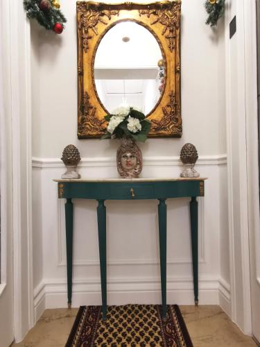 a console table with a mirror on a wall at Il galleone in Messina