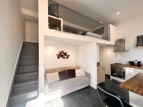 - un salon avec un escalier, un canapé et une table dans l'établissement Sweet Loft centre ville de Menton, à Menton