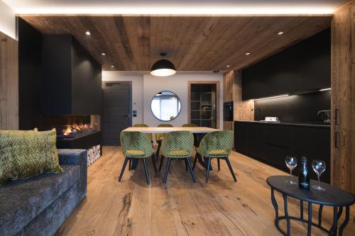 cocina y comedor con mesa y sillas en DOLOMITI EXCLUSIVE YOUR MOUNTAIN SUITE en Pozza di Fassa