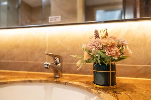 a vase of flowers sitting on a bathroom sink at Damei Xian -Kunming Road Branch in Xi'an