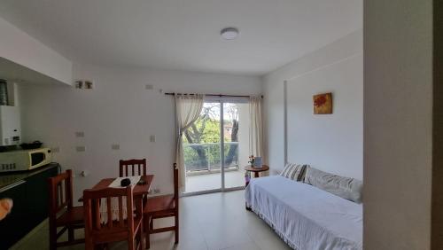 Habitación con cama y cocina con ventana en Deptos Bajo la Viña en San Salvador de Jujuy