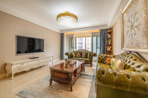 a living room with two couches and a tv at Damei Xian -Kunming Road Branch in Xi'an