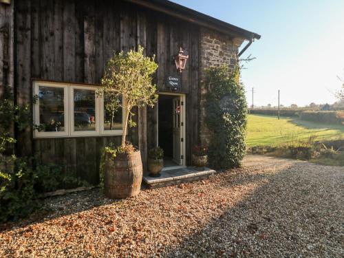 a barn with a tree in front of it at Lake View in Crediton