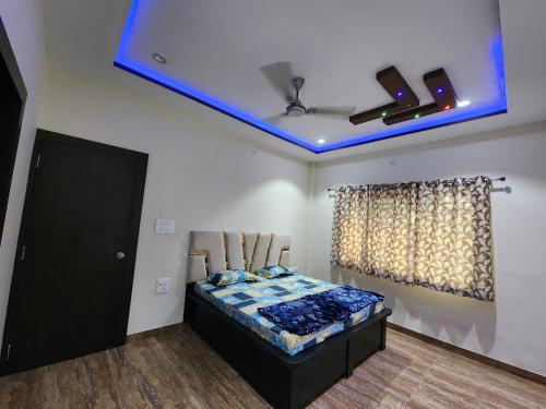 a bedroom with a bed with a blue ceiling at Holiday Home in Ujjain