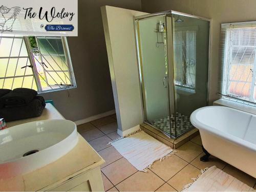 uma casa de banho com um chuveiro, uma banheira e um lavatório. em The Browns' - Cottage Suites em Dullstroom