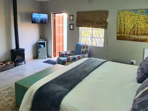 um quarto com uma cama grande e uma lareira em The Browns' - Cottage Suites em Dullstroom