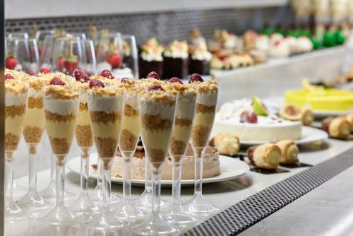 a table with several wine glasses with desserts at Atlantica Mikri Poli Crete in Makry Gialos