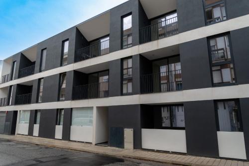 an exterior view of a black apartment building at Modern apartment with balcony and free parking in Porto