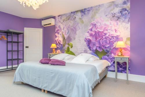 a purple bedroom with a bed with purple flowers on the wall at Château de la villeneuve in Saint-Marcel