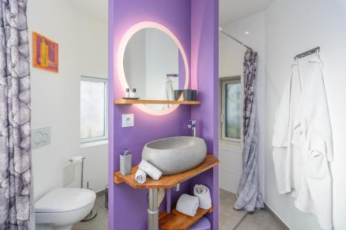 a purple bathroom with a sink and a mirror at Château de la villeneuve in Saint-Marcel