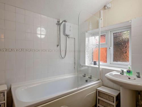 a white bathroom with a tub and a sink at 2 bed in Stanhoe POCN8 in Stanhoe