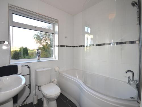 a bathroom with a tub and a toilet and a sink at 2 bed property in Whitsand Bay TYHAN in Saint Germans