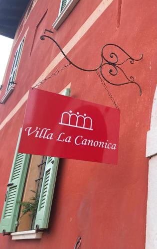 a sign on the side of a red building at B&B Villa la Canonica con piscina a Padernello in Farfengo
