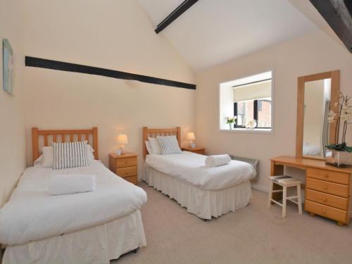 a bedroom with two beds and a desk and a window at 2 bed property in Shaftesbury 28678 in Sedghill