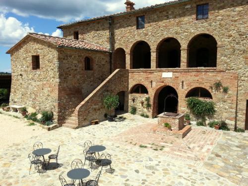 a building with tables and chairs in front of it at Locanda Cugnanello in Anqua