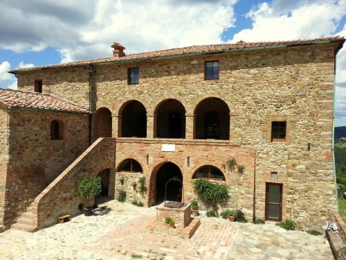 a large stone building with arches and a staircase at Locanda Cugnanello in Anqua