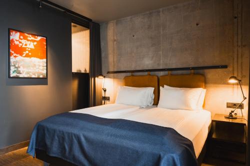 a bedroom with a large bed with a blue blanket at Exeter Hotel in Reykjavík