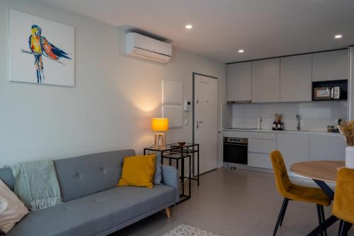a living room with a blue couch and a kitchen at Modern apartment with balcony and free parking in Porto