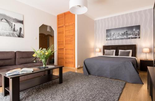 um quarto de hotel com uma cama e um sofá em Modern Apartment at Classic Warsaw. Free parking. em Varsóvia