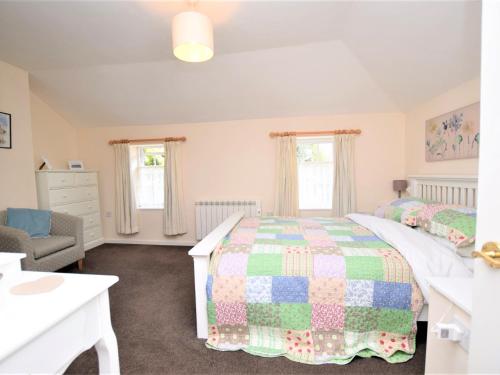 a bedroom with a bed and a chair and windows at 1 Bed in Wymondham 43278 in Wymondham