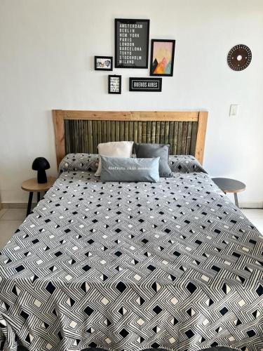 a large bed in a bedroom with several pictures on the wall at El Porteño in San Pedro