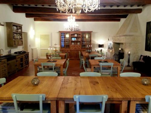 a dining room with wooden tables and chairs and a chandelier at Locanda Cugnanello in Anqua