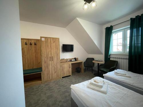 Pokój z 2 łóżkami, biurkiem i telewizorem w obiekcie Centrum Turystyki Wiejskiej Alicja w mieście Księżpol