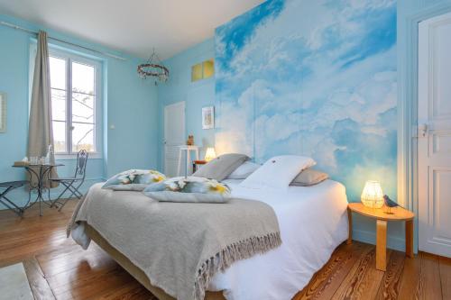 a bedroom with a large bed with a blue wall at Château de la villeneuve in Saint-Marcel