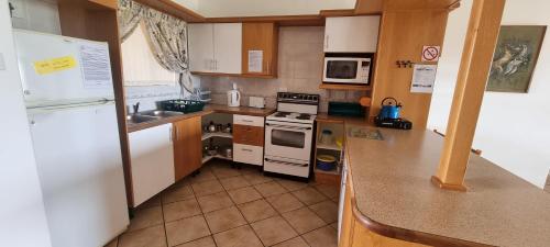 a kitchen with a white refrigerator and a stove top oven at Kleinmond Panorama Holidays in Kleinmond