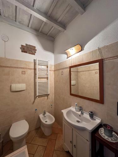 a bathroom with a sink and a toilet and a mirror at Appartamento in storica Cascina Lombarda Cusago Rho-Fiera-San-Siro in Cusago