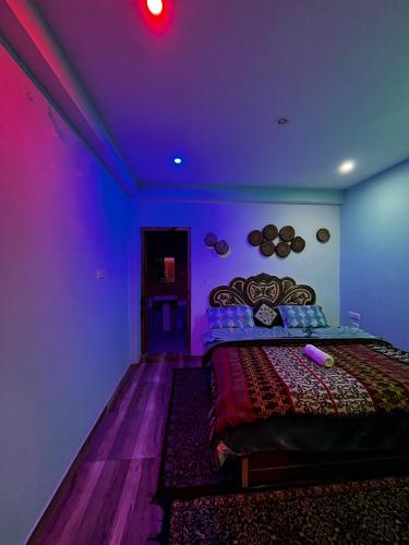 a room with a bed with a purple ceiling at Karma Guest House and Cafe in Kalgha