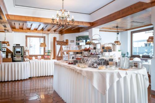 a restaurant with white tables with food on them at Hotel Dachstein in Filzmoos